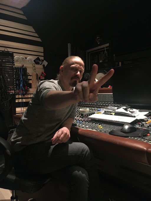 Tuomas showing his signature V for Victory sign behind a mixing console